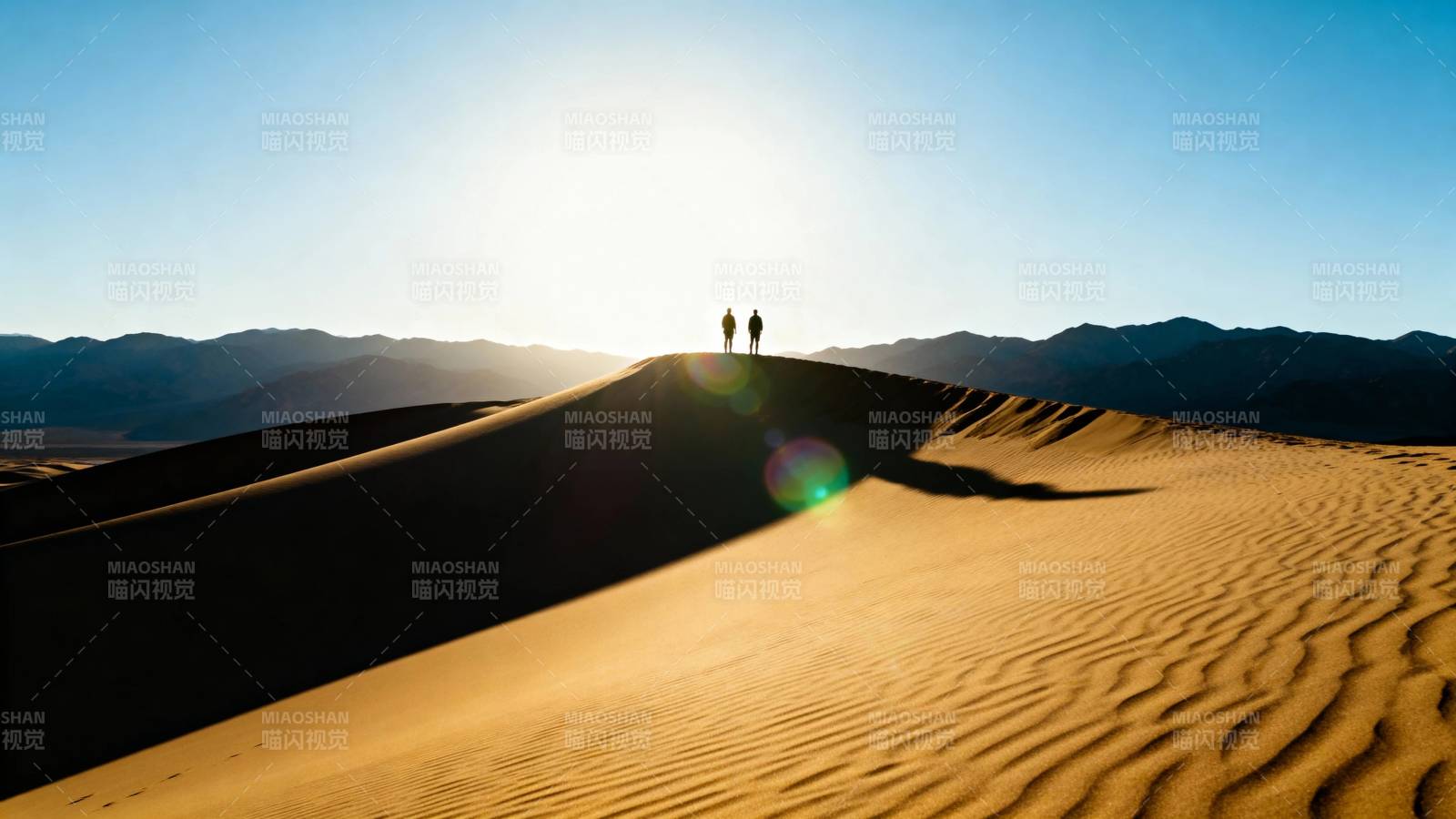 沙漠夕阳 两人登顶沙丘图片