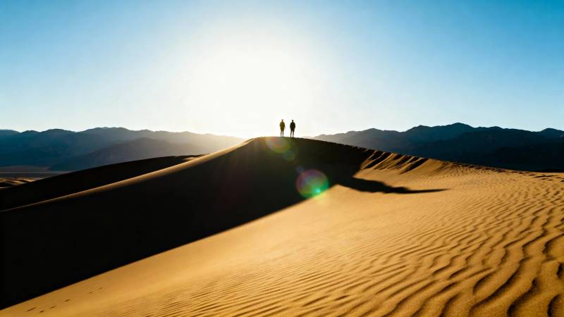 沙漠夕阳 两人登顶沙丘图片