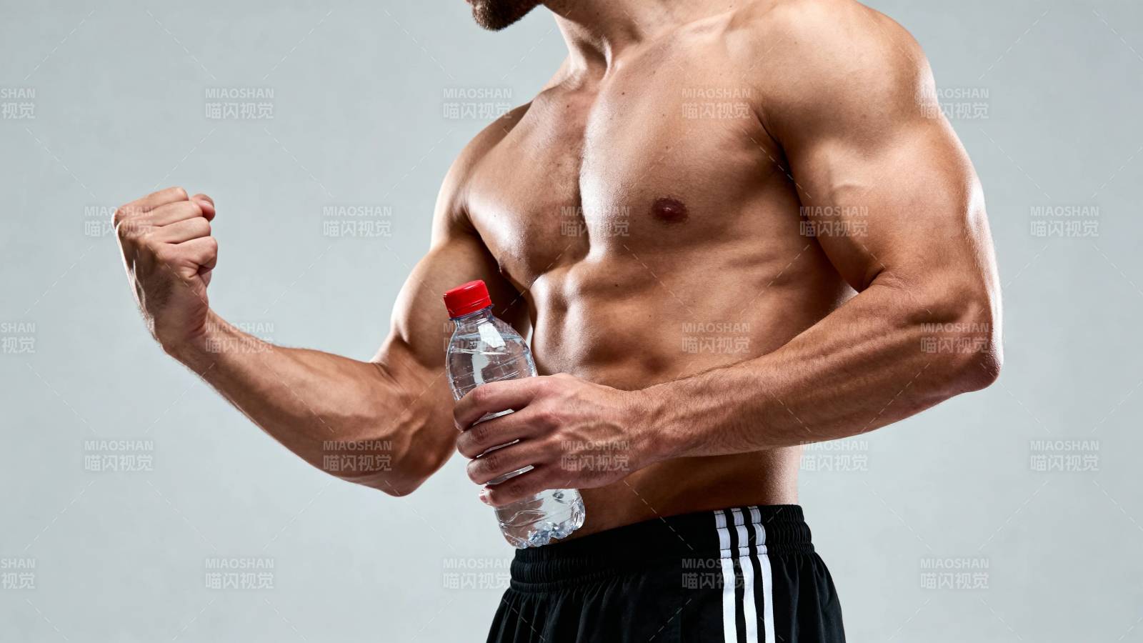 健硕男持水瓶秀肌肉图片