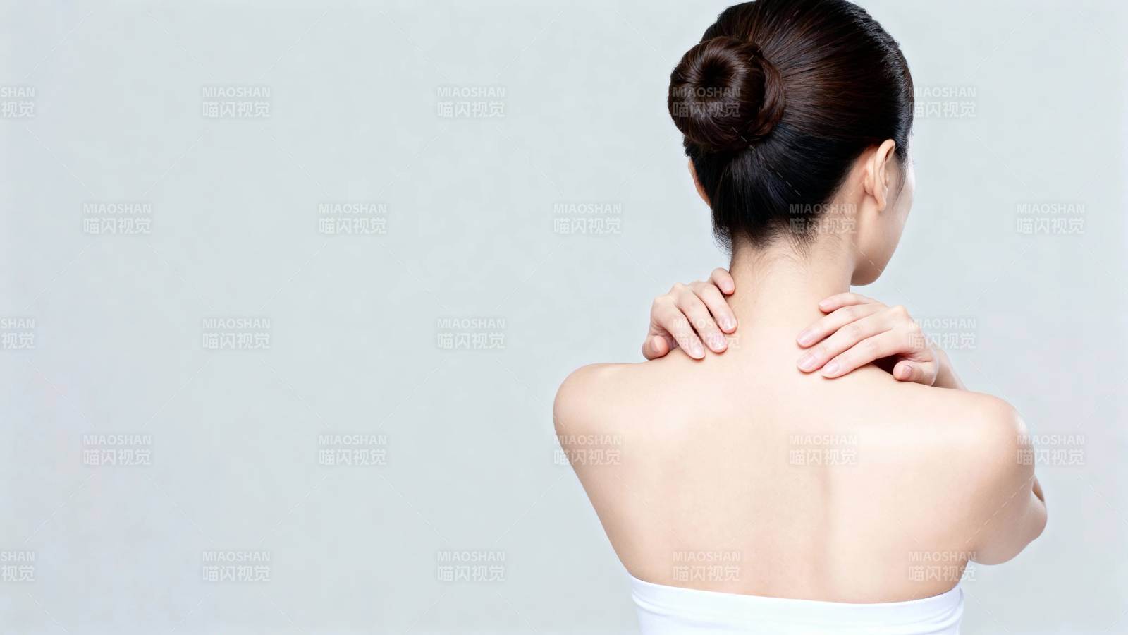 女子背对镜头 手抚肩颈图片