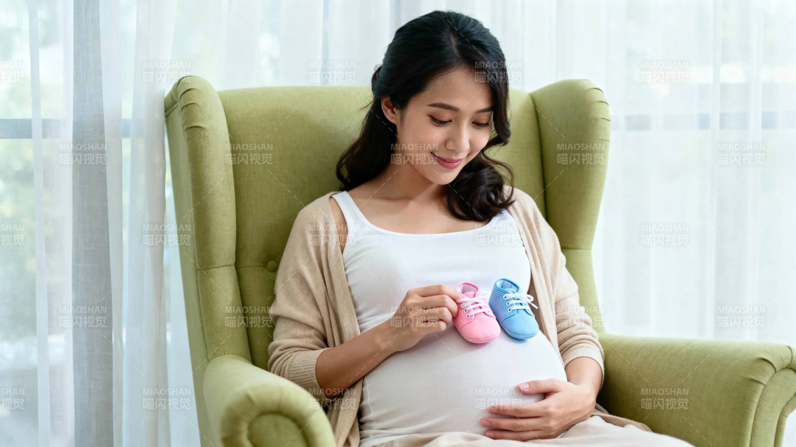 孕妈轻抚孕肚 手握婴儿鞋图片
