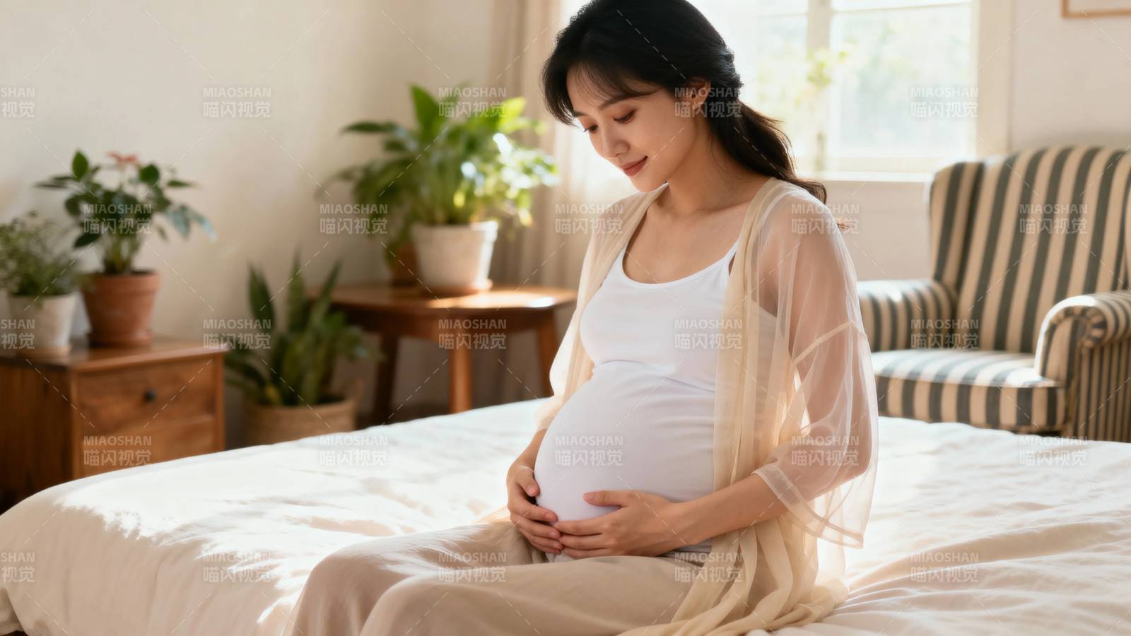 孕妇静坐床畔 轻抚孕肚图片