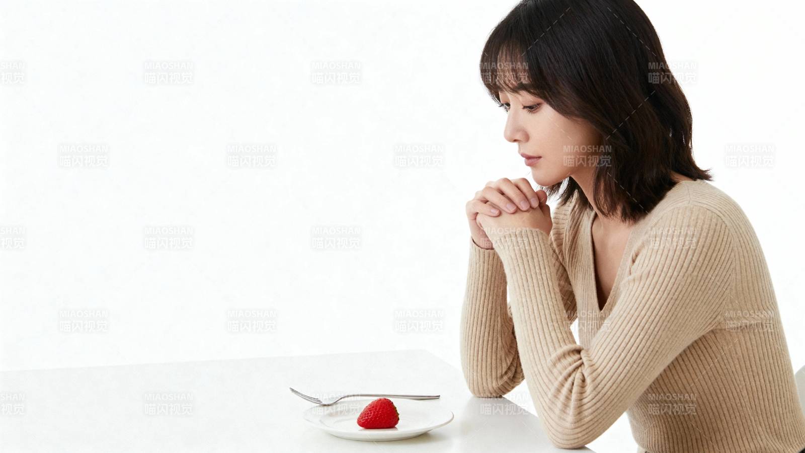女子凝视盘中草莓 神情若有所思图片