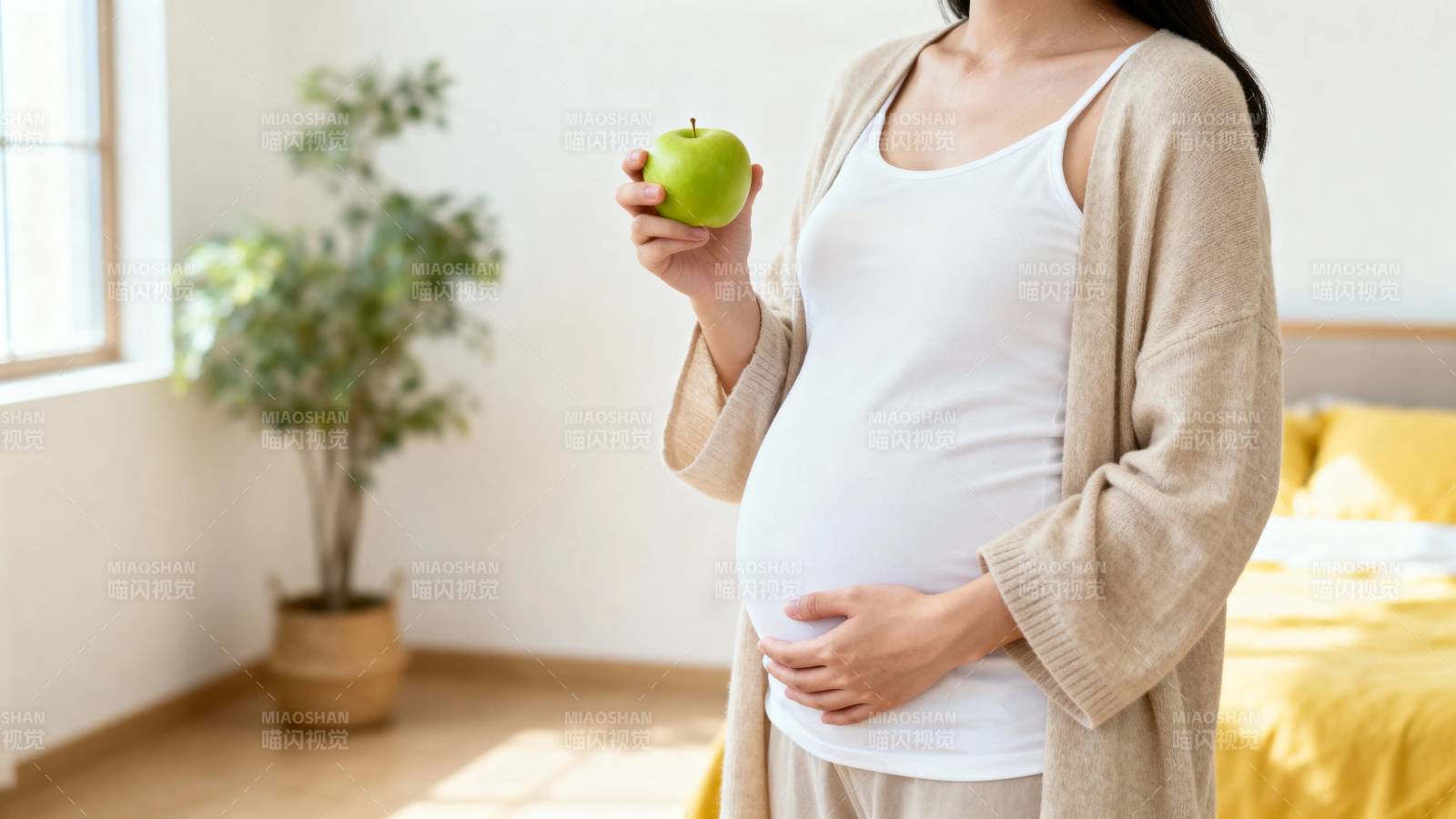 孕妈手持青苹果 温馨居家照图片