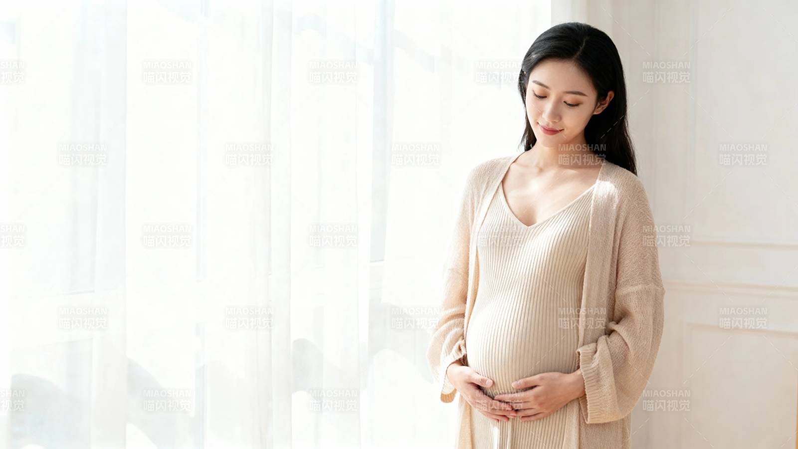 孕妇窗边轻抚孕肚 温柔静谧图片