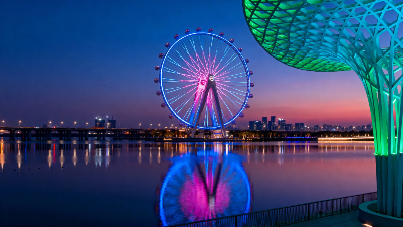 夜景摩天轮与彩色树影倒映水中图片