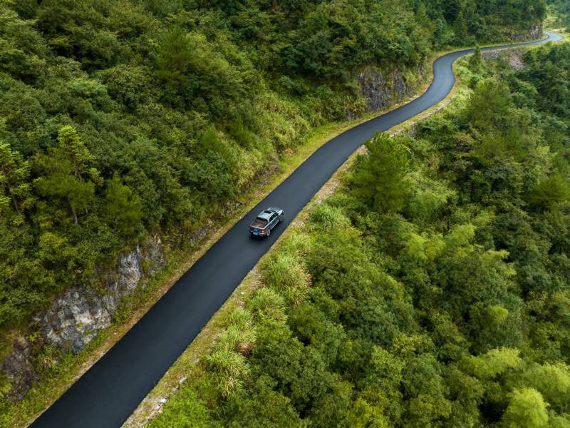 山间公路 一车穿行绿海图片