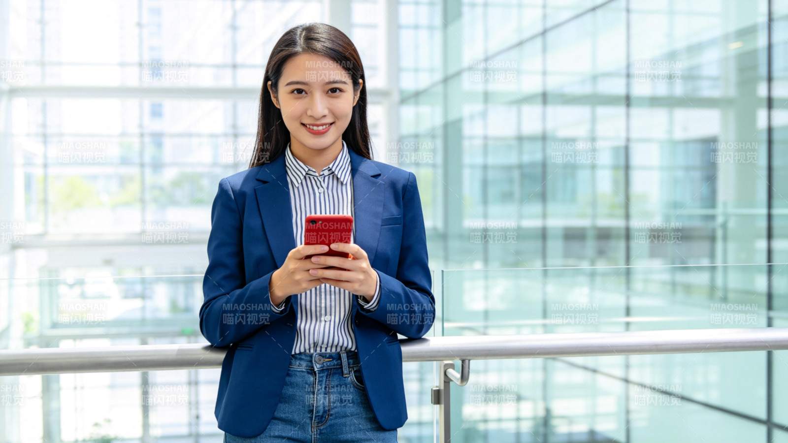 职场女性持红手机微笑图片